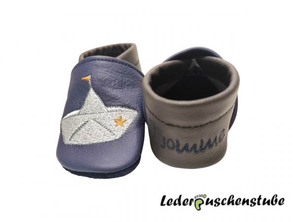Lederpuschen dunkelblau-dunkelbraun; personalisiert Ferse (dunkelblau) mit Papierboot (grau-anthrazit Fahne braun) und Anker (grau-anthrazit-weiß Herz braun)